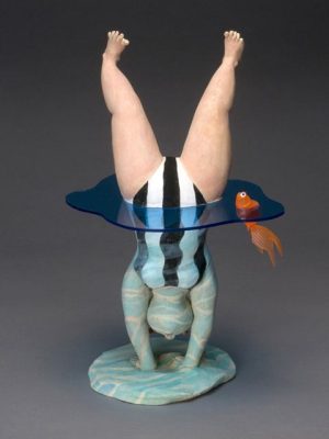 Menina fazendo uma bananeira no lago